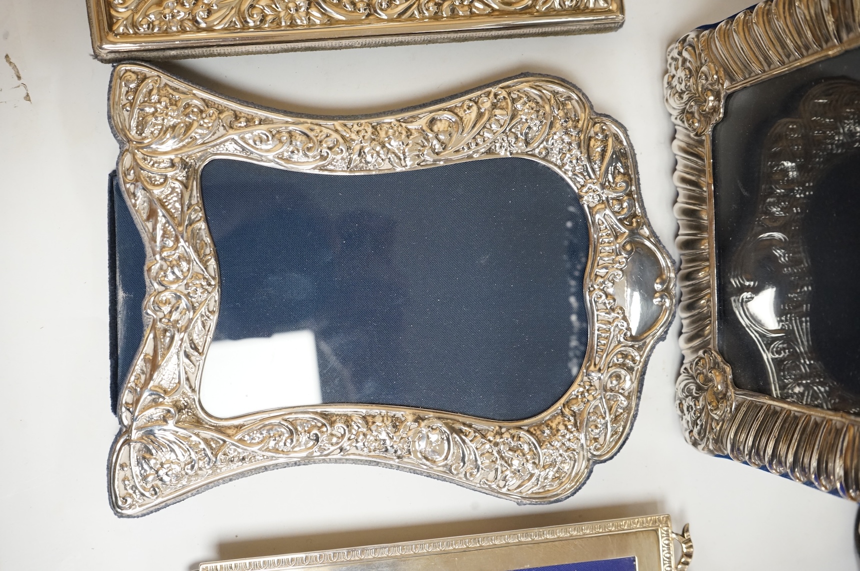 A George V silver mounted rectangular photograph frame, with ribbon bow crest, by Stokes & Ireland Ltd, Chester, 1912, 18.2cm including crest, together with ten other modern silver mounted photograph frames, largest 29.4